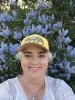 Woman taking a seflie in front of a flowering bush